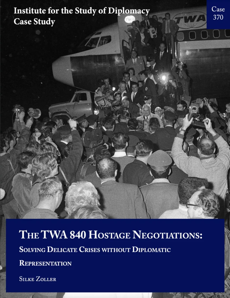 Black and white photograph of people getting out of a plane, with a large crowd surrounding the plane