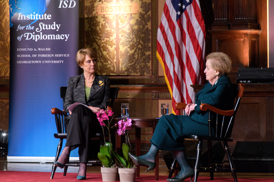 Amb. Bodine and Madeleine Albright having a conversation on stage