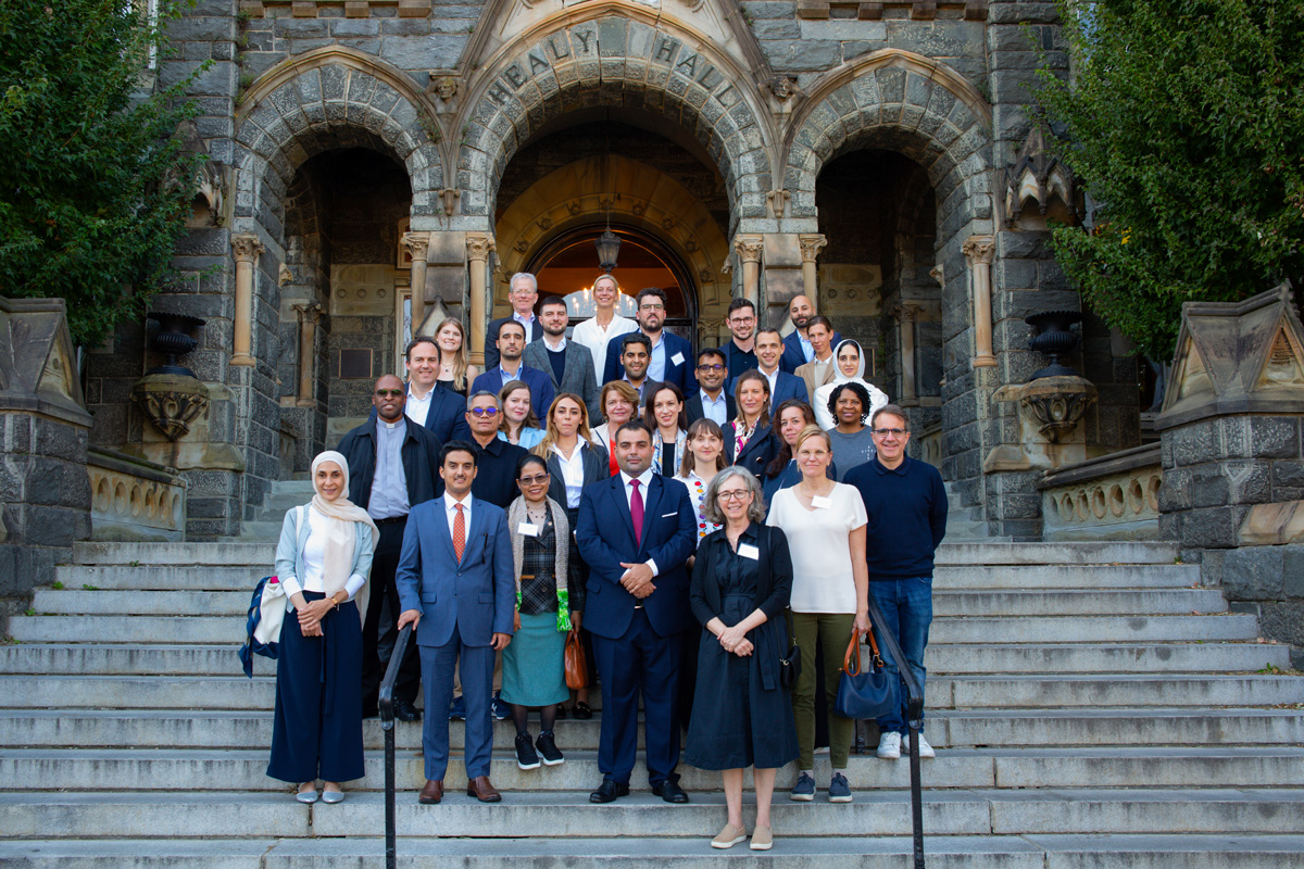 Group of 20 professionals standing on the steps in front of a historic Georgetown building